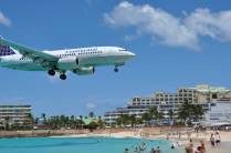 Avião de grande porte passa sobre Maho Bay, praia de Sint Maarten - Caribe, fazendo a alegria da galera!